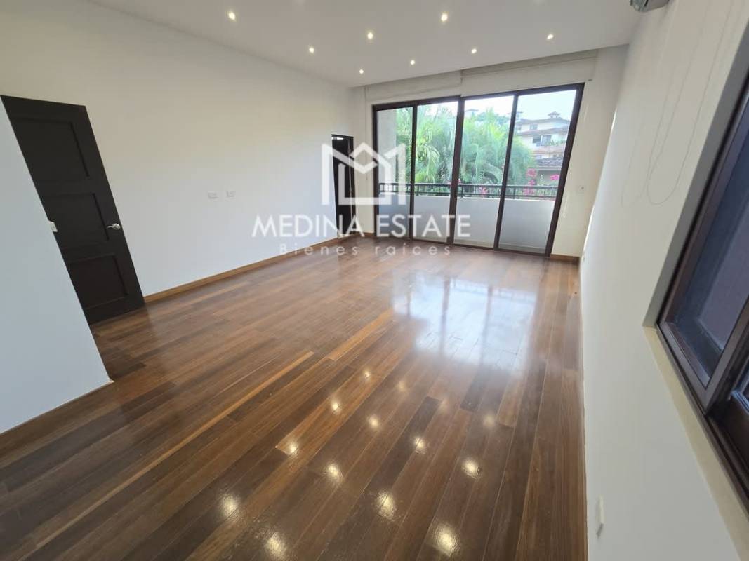Modern living room with wood floors and sliding doors opening to terrace Embassy Club Clayton Panama