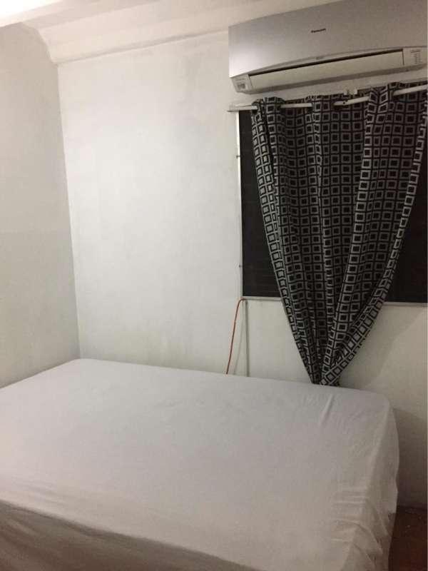 Bedroom in Villa Gabriela apartment with wall AC and white decor Panama City