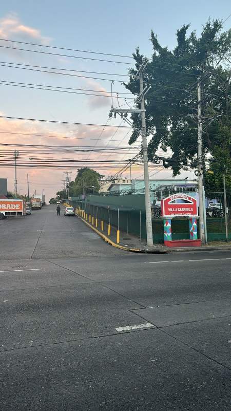 Street access to Villa Gabriela residential complex with signage fencing and vehicles
