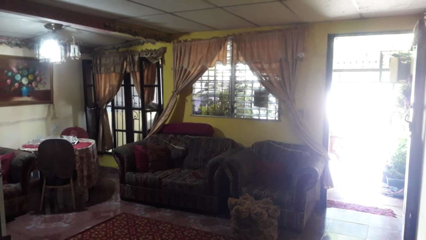 Traditional living room with dining, big windows, sofa set, and curtains Villa Grecia Panama