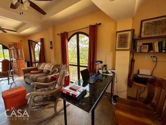 Mediterranean rustic interior with arched windows, workspace, and sofas in Coclé countryside house