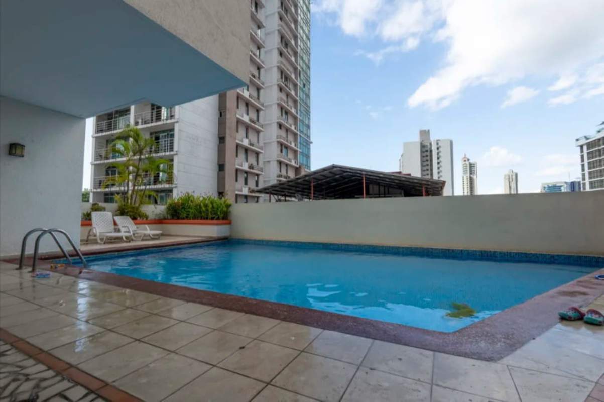 Outdoor swimming pool in PH Via Argentina building with lounge chairs Panama City