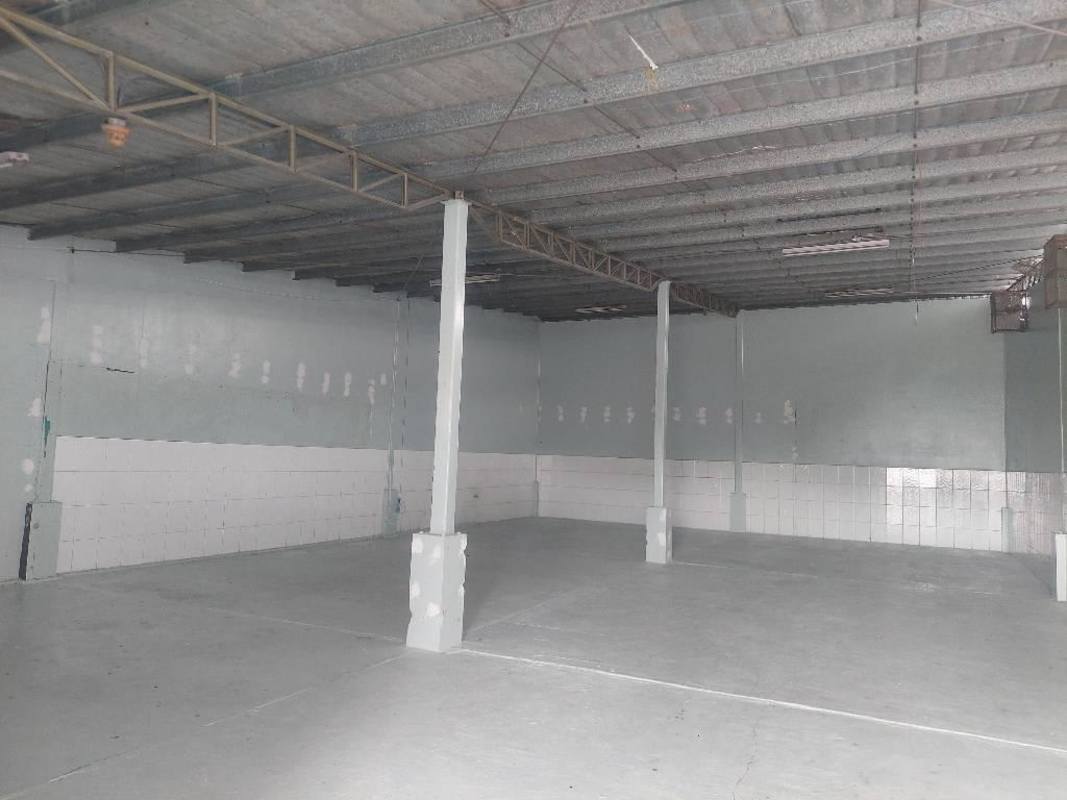 Industrial warehouse with high ceiling, support columns, partial tiled walls and concrete flooring in Panama