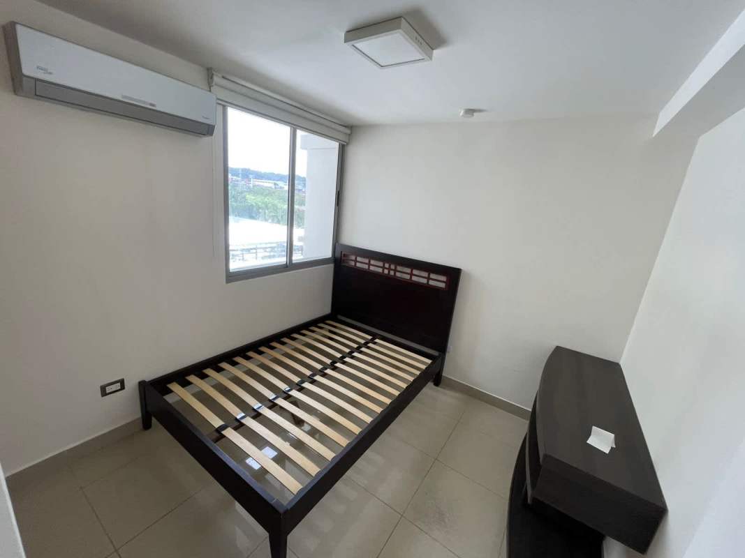 Bedroom with large window, AC unit, minimalist furniture at PH Rokas Condado del Rey Panama
