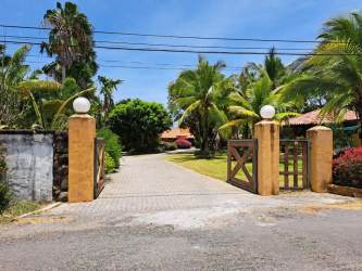 Private gate to sandy beachfront with palm trees at Punta Barco Panama luxury property