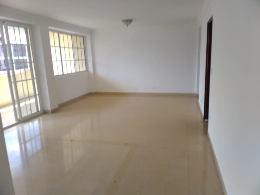 Kitchen with brown cabinets, white countertops and large window in PH Vía Argentina Residences Panama