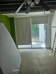 Bedroom with ceiling fan, sliding glass door with blinds opening to garden at PH Napa Village Playa Blanca