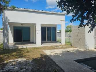 Covered patio area with sliding glass doors, unfinished yard and privacy wall at PH Napa Village Playa Blanca