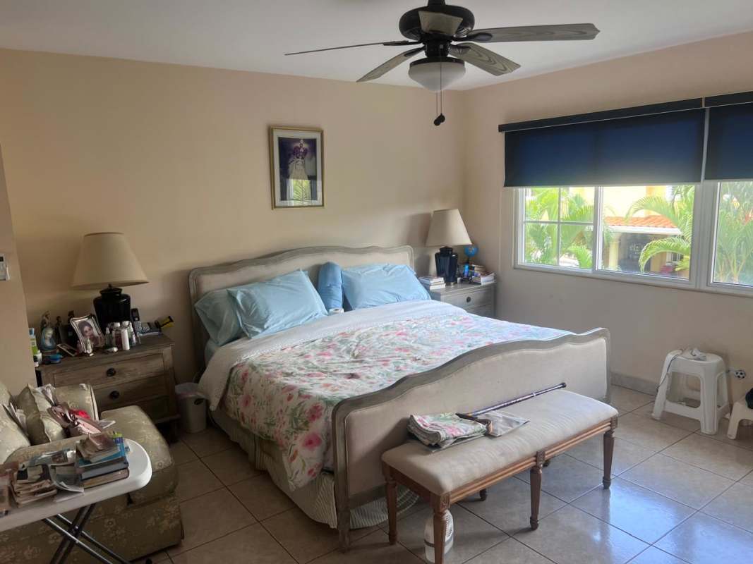 Primary bedroom at Costa Dorada with en suite bath, tiled floors, large windows and ceiling fan Costa del Este Panama