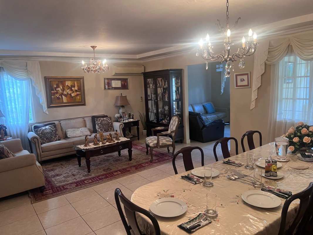 Light-filled dining area with arched window, chandelier, and tiled floors at Costa Dorada house Costa del Este Panama City