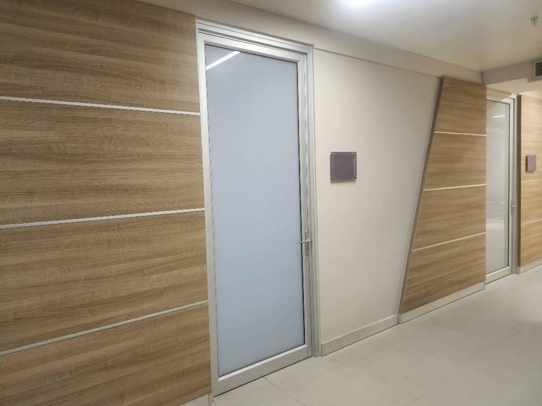 Modern office corridor with glass doors and wood panels TownCenter Costa del Este Panama