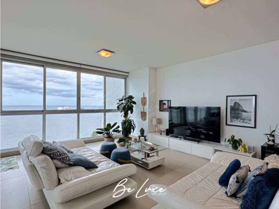 Modern living room with panoramic oceanfront views and white sectional sofa at PH Oceanaire Panama City
