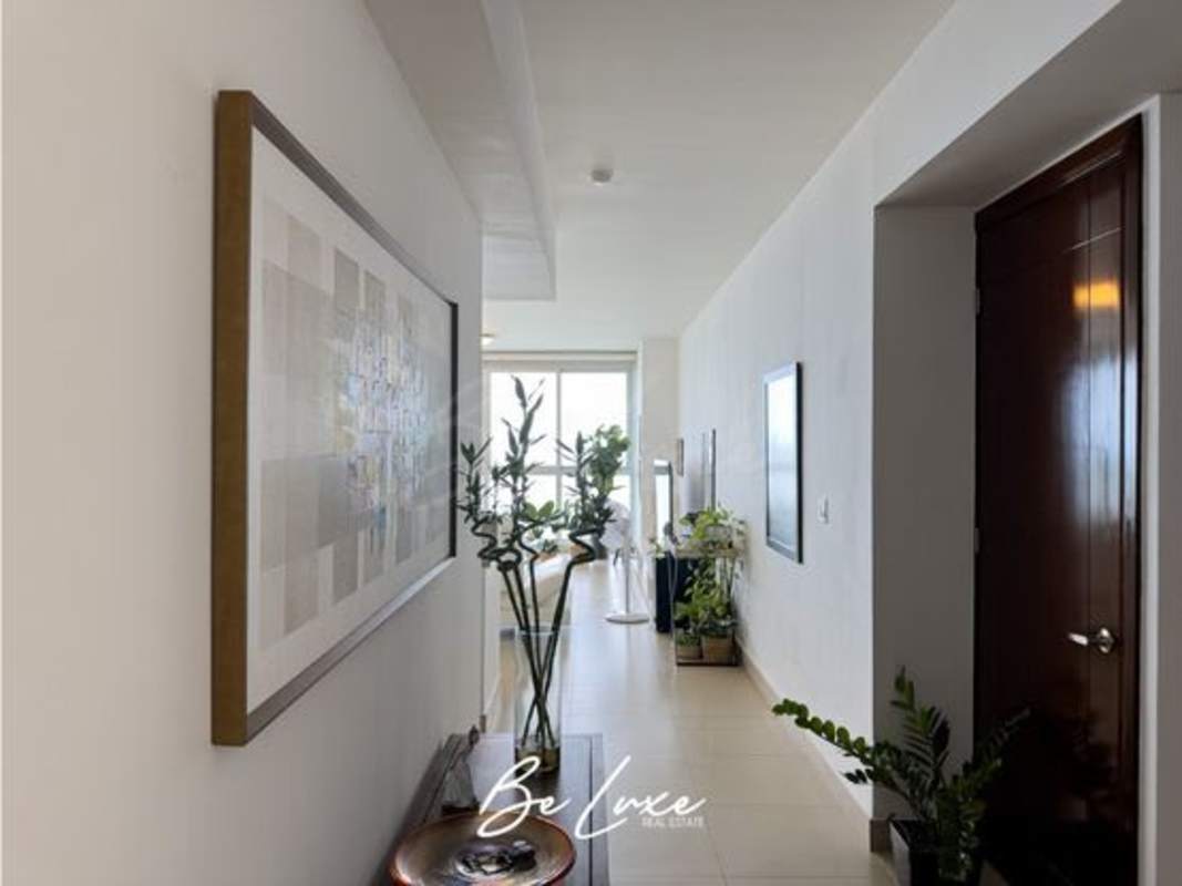 Modern walk-in closet with dark wood finish and organized shelving at PH Oceanaire