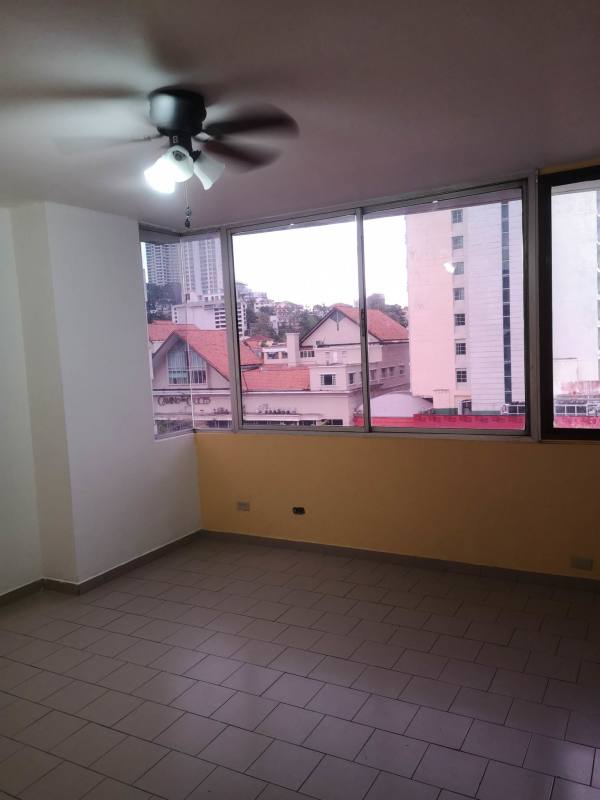 Empty living room with large windows, tiled floor, ceiling fan offering city view - PH El Dorado