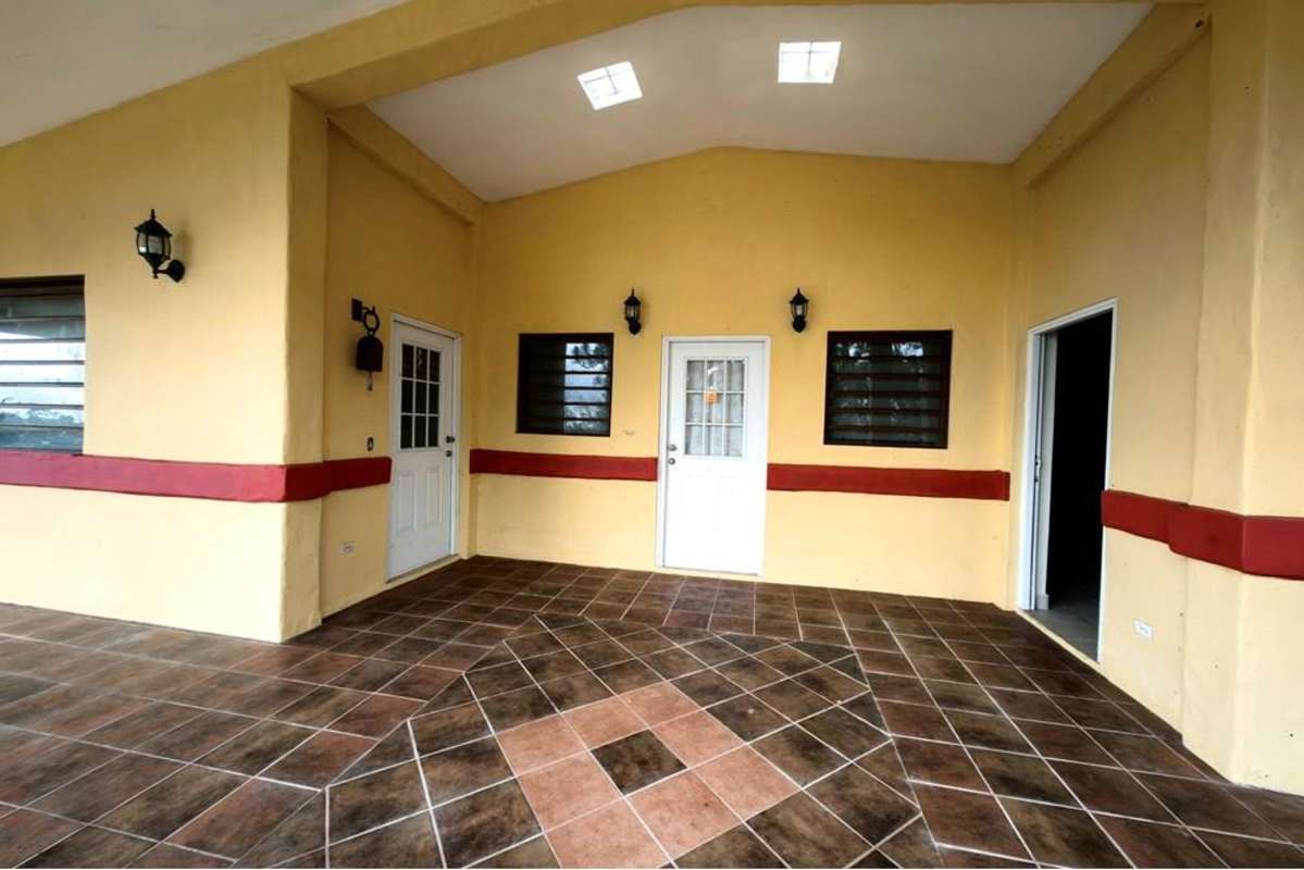 Spacious living area with stone fireplace, large windows and tiled floor in Cerro Azul mountain property