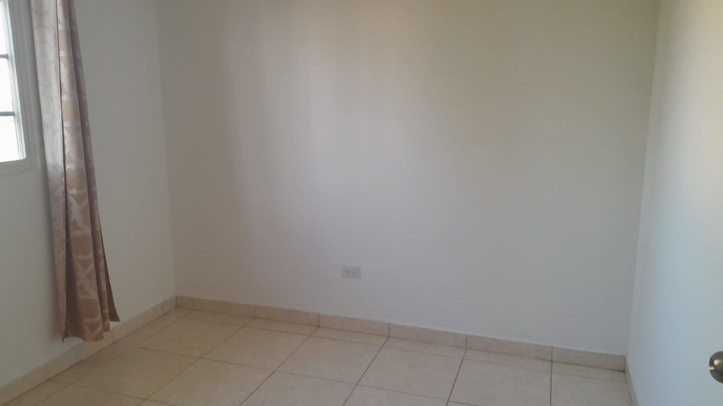 Bedroom with built-in closet and neutral décor in corner house for sale Los Álamos Pacora Panama