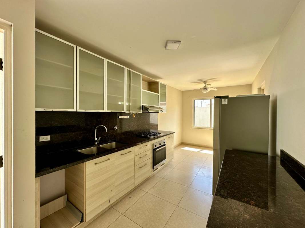 Bright modern kitchen with granite countertops, stainless appliances in Versalles duplex Panama City