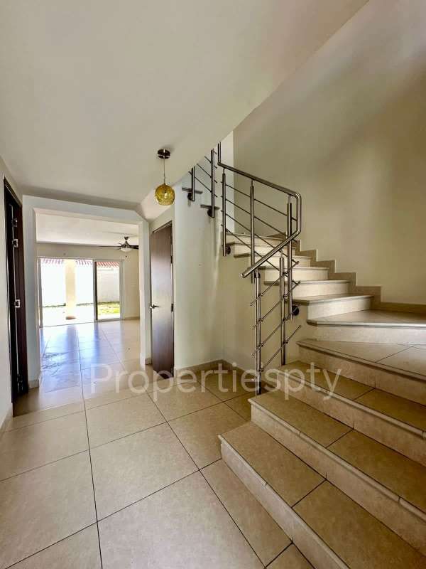 Spacious entrance foyer with metal staircase and natural light in Versalles Panama duplex