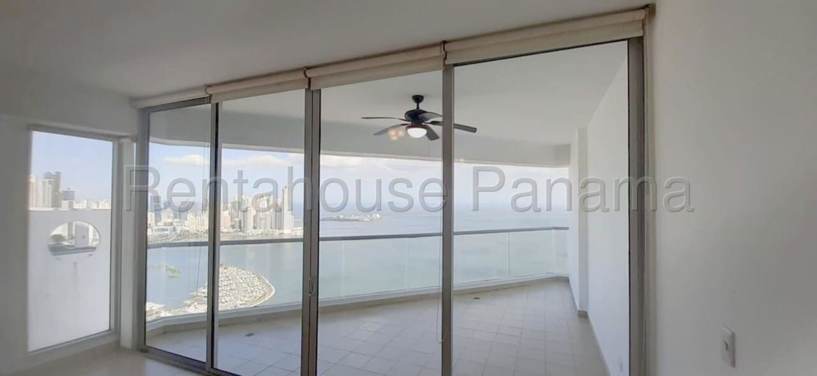 Living room with floor-to-ceiling windows and balcony overlooking ocean at Rivage Tower Panama