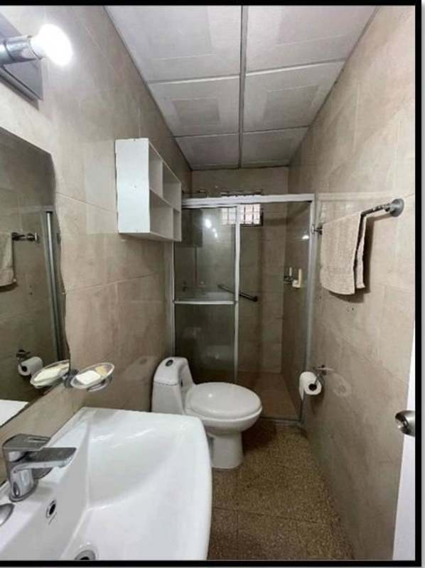 Contemporary bathroom with beige tiles, glass shower enclosure, mirror and sink Cerro Viento Panama