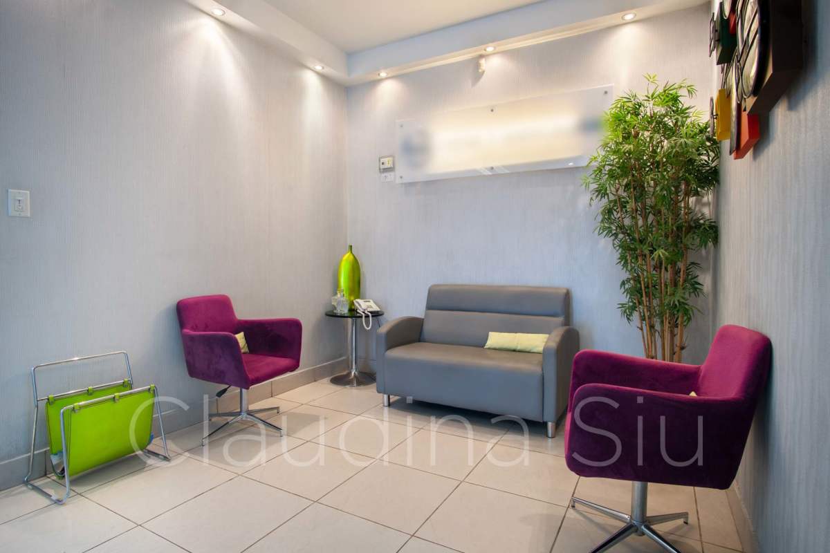 Modern reception waiting area with purple chairs and potted plant PH Centro Empresarial El Carmen