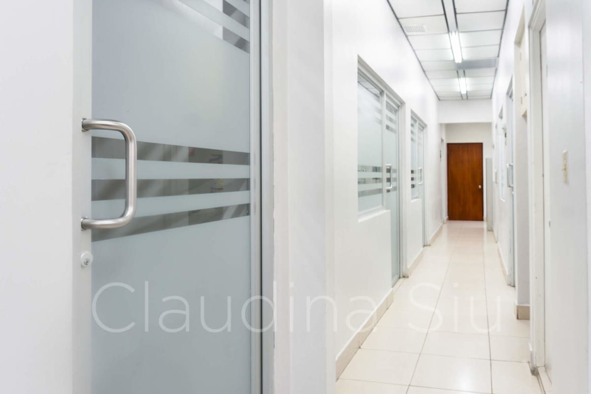 Sleek office corridor with frosted glass doors and tiled floors at PH Centro Empresarial El Carmen Panama