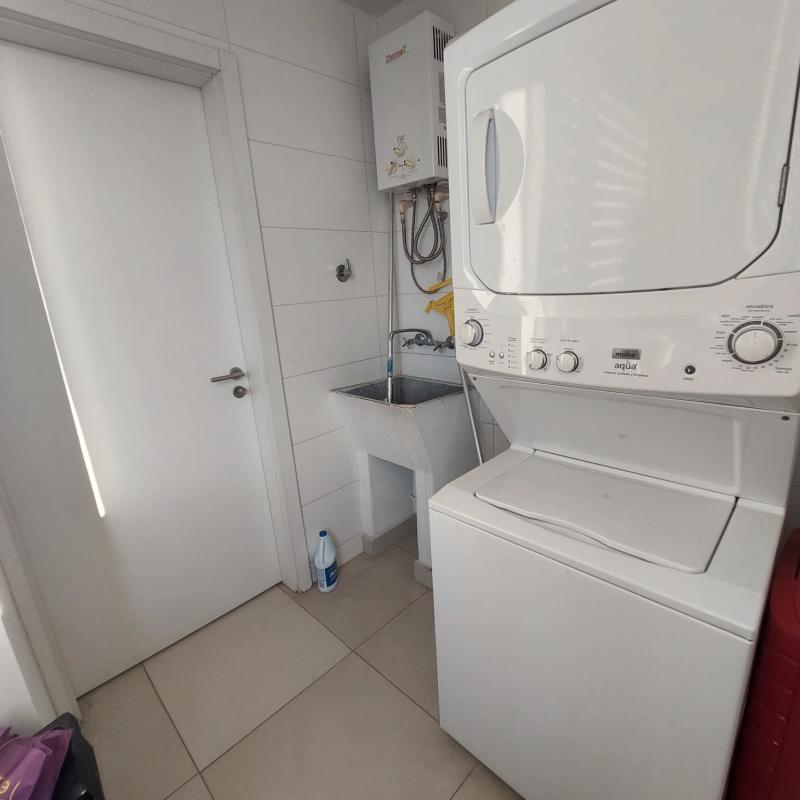 Laundry room with stacked washer-dryer and sink in PH Sky Park El Carmen Panama
