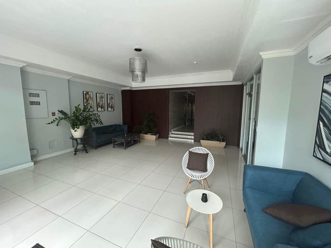 Elegant lobby with blue sofas and glass doors at PH San Francisco Park Panama City