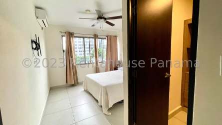 Living room with sofa, open kitchen and balcony at PH Midrise Panama Pacifico