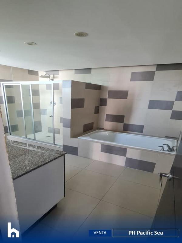 Penthouse hallway with large window showcasing ocean and skyscraper views in PH Pacific Sea Panama City