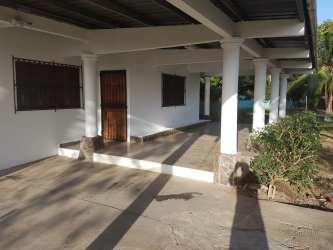 White house exterior with porch columns and tiled floor near Playa Blanca in Coclé Panama