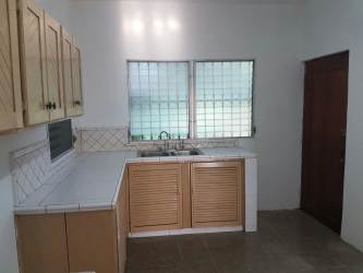 Traditional kitchen with wood cabinets and tiled counters in Coclé house