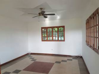 Living room with tiled floors, fan and wood trim in house near Rio Hato Panama