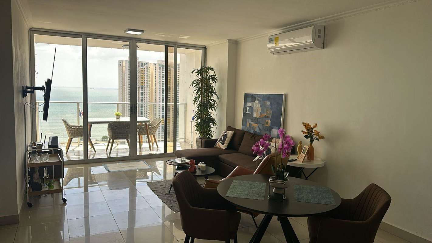 Contemporary living room with dining area and ocean view balcony in PH Serenity at the Bay Panama City