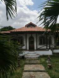 Living room with hammock, arched window, dining set, rustic decor in Penonomé Panama