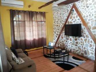 Rustic living room with ceramic tiles and flat TV in Panama house for sale