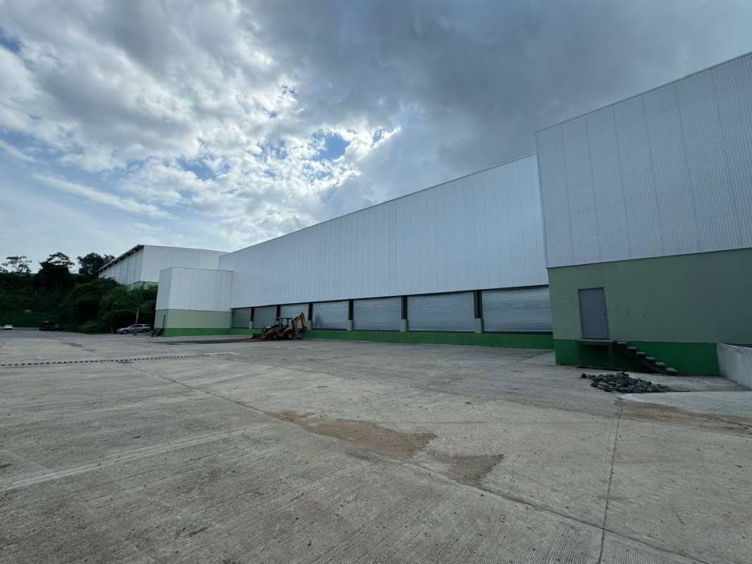 Industrial warehouse with multiple loading docks and concrete yard in Panama City