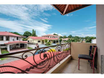 Covered tiled balcony with ornate railing neighborhood view Villa Venice El Terronal David Panama
