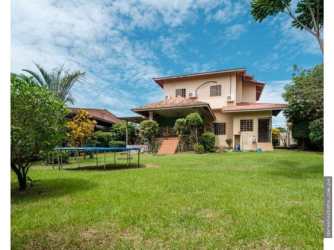 Spacious backyard with trampoline mature trees lush landscaping two-story house Villa Venice David Panama
