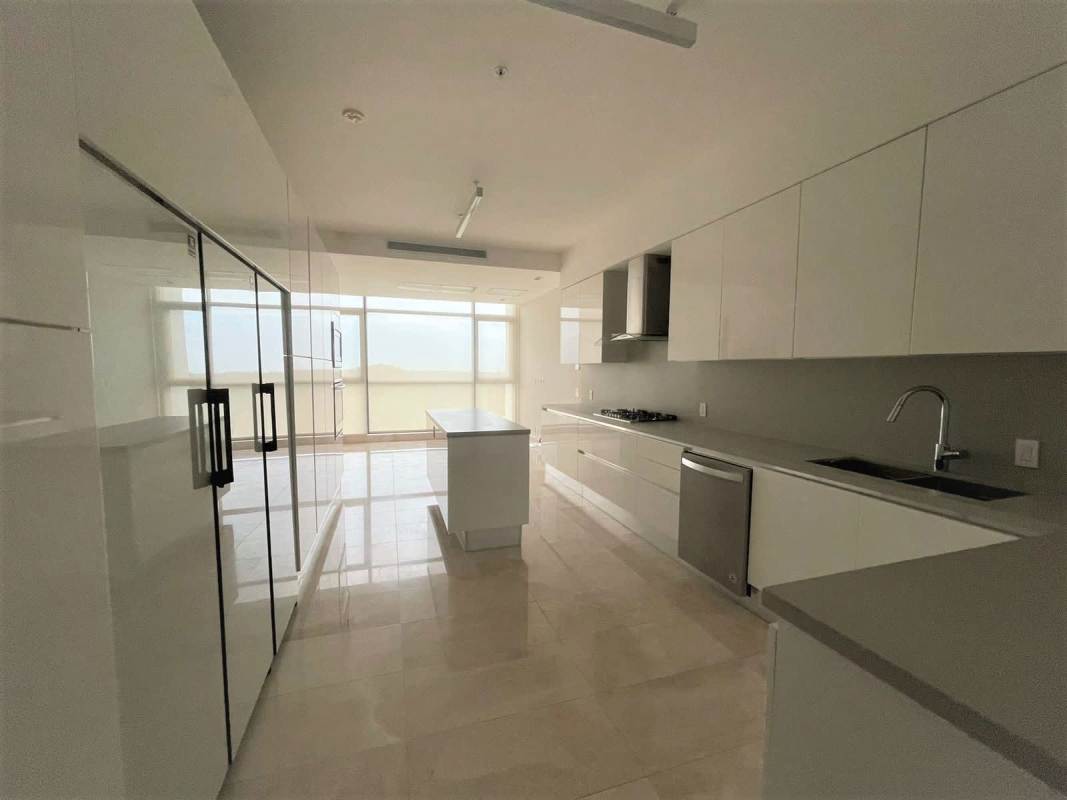 Spacious modern kitchen with island, sleek cabinets, and large windows at PH Albatros Santa María