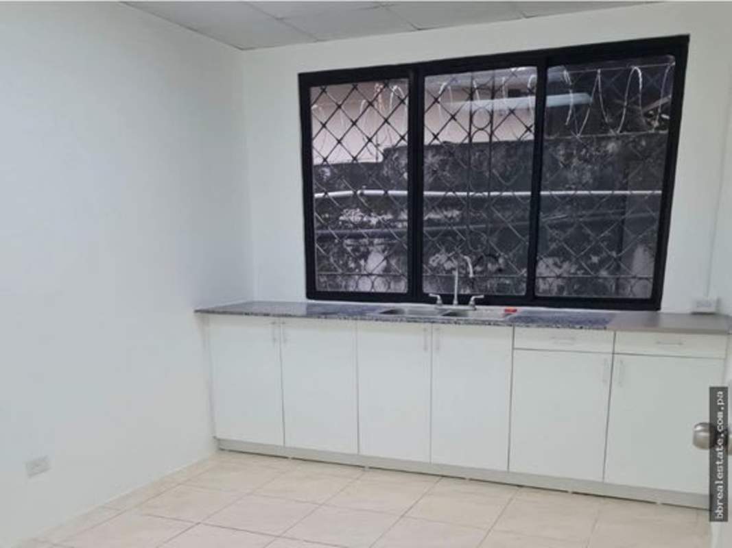 Minimalist kitchen with granite counter, sink, large window with bars in office for rent Obarrio Panama City