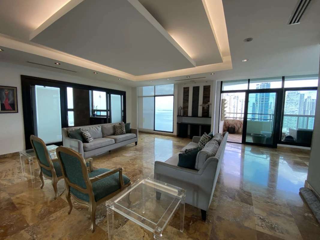 Large island kitchen with black cabinetry and city views in penthouse rental PH Ocean Club Panama