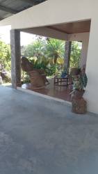 Covered veranda patio with garden furniture surrounded by lush greenery Los Algarrobos Dolega Panama