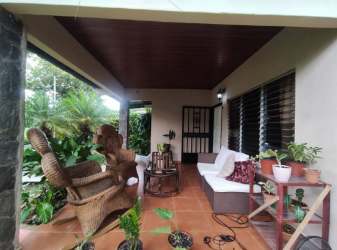 Covered patio with wicker furniture, natural decor and plants in Los Algarrobos David Panama