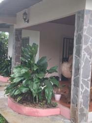 Porch with stone pillars, landscaped garden and iron door in Los Algarrobos David Panama