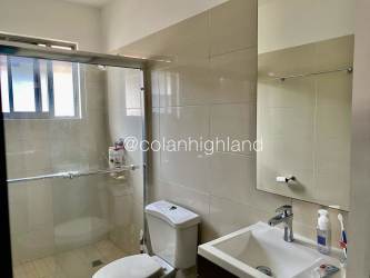 Modern bathroom with glass shower enclosure and tile finish in Panama Pacifico home for sale