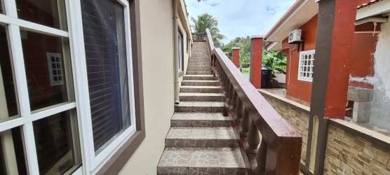Tropical yard with palm trees, grass and stone wall, Caribbean villa San Marino Ocean Front Colón Panama