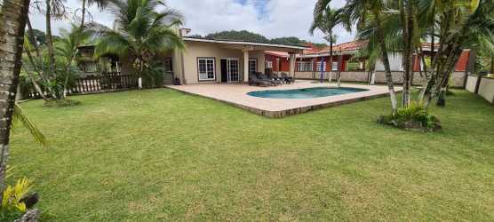 Private backyard swimming pool with garden, palm trees in exclusive beach villa Colón Panama Caribbean coast