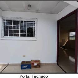 Residential access street lined with single-story houses in Las Lomas David