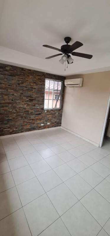 Bright living room with stone accent wall, ceiling fan, AC unit in Dorado Lake Residence Panama City